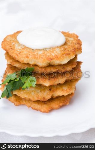 fried potato pancakes with parsley on white plate