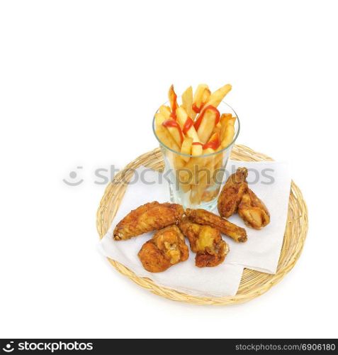 fried potato sliced as french fries in a glass and fried chicken drumsticks and wings on a paper serviettes in a wicker or bread basket over white background