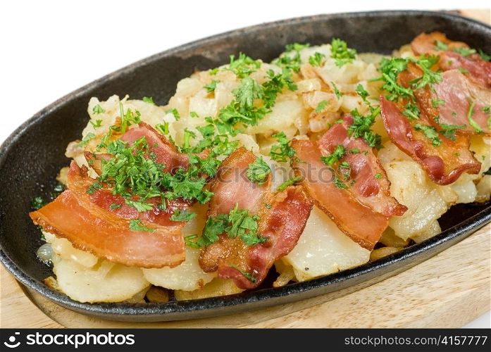 Fried potato with bacon and vegetables on a white