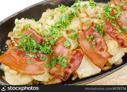 Fried potato with bacon and vegetables on a white