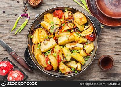 Fried potato with tomato and onion.Baked fried potatoes. Potatoes fried in pan