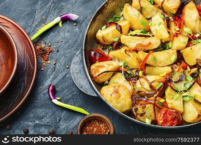 Fried potato with tomato, onion.Baked fried potatoes. Roasted potato in a frying pan