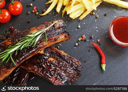 fried potatoes and pork ribs on aplate