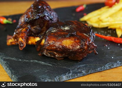 fried potatoes and pork with bone on plate