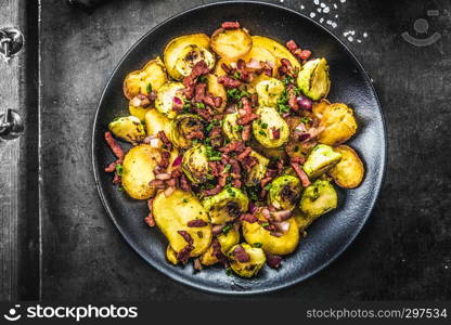 Fried potatoes with Brussels sprouts and bacon on a plate