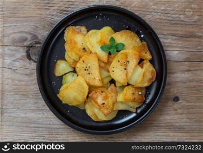 Fried potatoes with pepper and salt on a plate.. Fried potatoes with pepper and salt on a plate