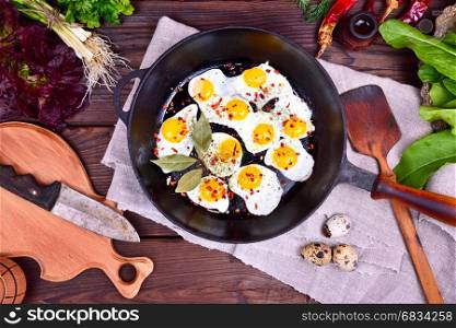 Fried quail eggs in a frying pan, top view
