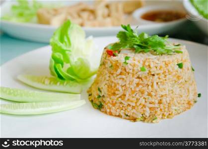 fried rice served with fresh vegetable on white plate