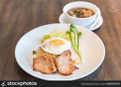 Fried rice with grilled pork and fried egg served with bak kut teh soup. Fried rice with grilled pork