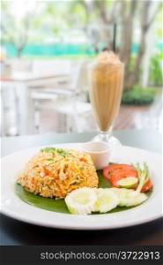 fried rice with iced coffee in restaurant background (Selective focus at fried rice)