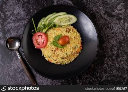 Fried rice with minced pork, tomato, carrot and cucumber on the plate