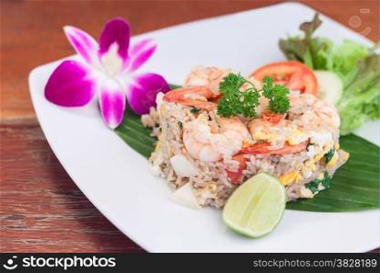 Fried rice with salted egg and shrimp on banana leaf decor by vegetable and orchid