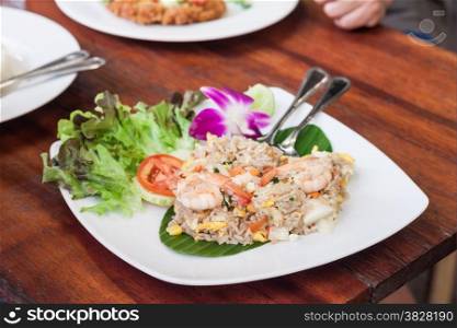 Fried rice with salted egg and shrimp on wooden table