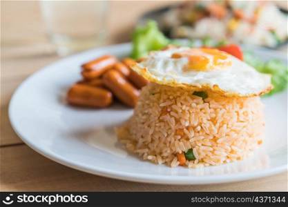 fried rice with sausage and fried egg on the table