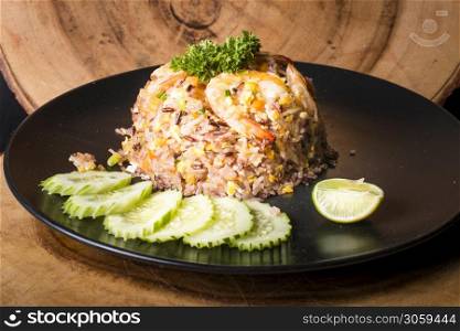 Fried rice with shrimp served with cucumber and lime