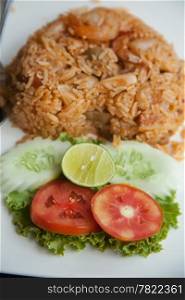 Fried rice with spicy colorful. With cucumber and tomatoes. Placed on a white plate.