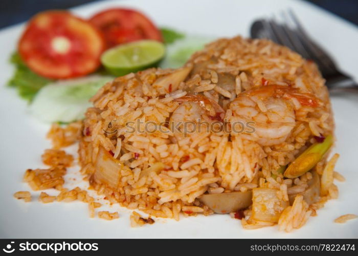 Fried rice with spicy colorful. With cucumber and tomatoes. Placed on a white plate.