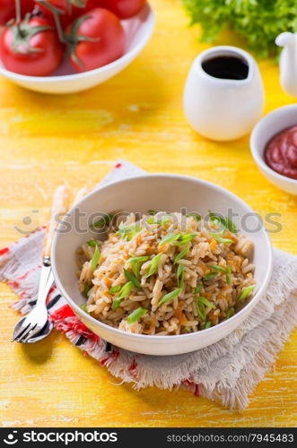 Fried rice with vegetables and green onion, fresh tomatoes and sauces
