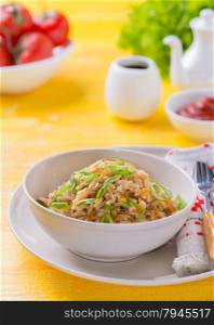 Fried rice with vegetables and green onion, fresh tomatoes and sauces, selective focus