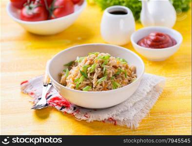 Fried rice with vegetables and green onion, fresh tomatoes and sauces, selective focus