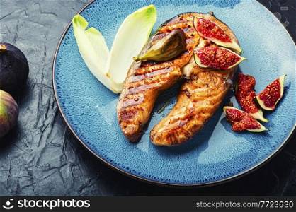 Fried salmon steak with figs.Baked trout on the plate. Grilled salmon with figs