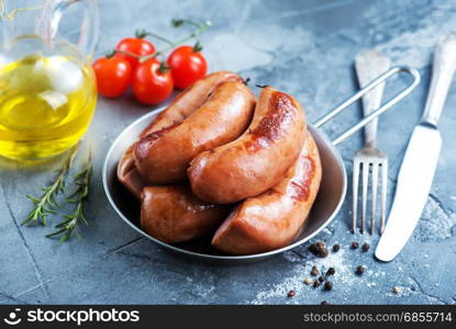 fried sausages in pan and on a table