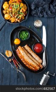 fried sausages with tomato sauce on black plate