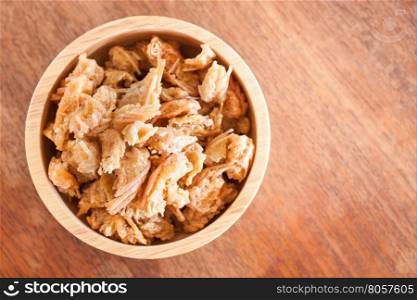 Fried shrimp chins snack in wooden bowl, stock photo