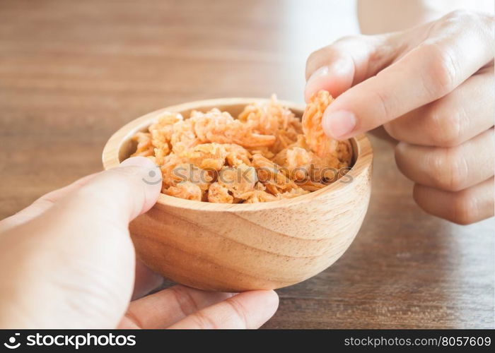 Fried shrimp chins snack in wooden bowl, stock photo