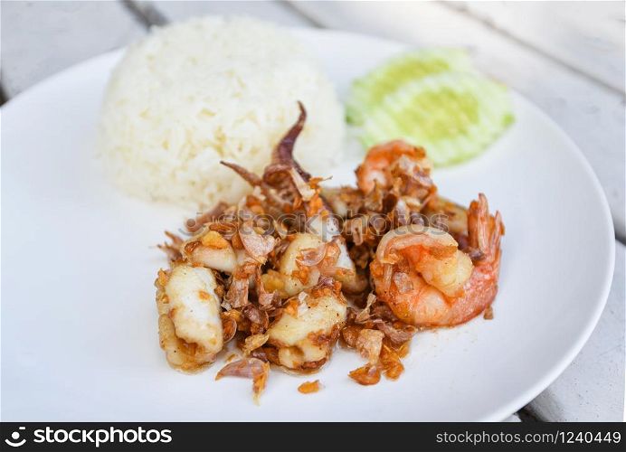 Fried shrimp squid fish with rice on white plate / Garlic Fried Seafood