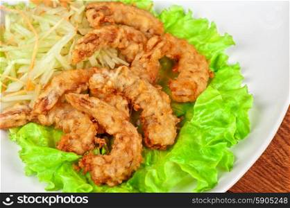 Fried shrimps. Fried shrimps with lettuce at white plate