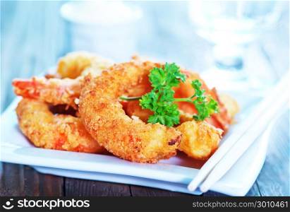 fried shrimps on plate and on a table