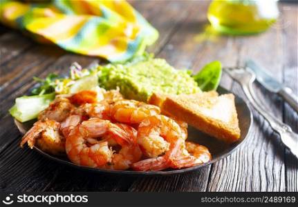 fried shrimps with fresh avocado and toasts. he<hy breakfast. fried shrimps with avocado and toasts