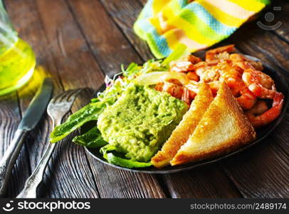 fried shrimps with fresh avocado and toasts. helthy breakfast. fried shrimps with avocado and toasts