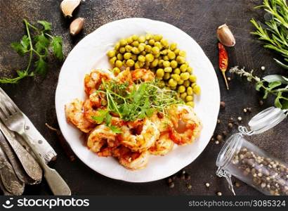 fried shrimps with green peas on plate