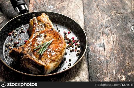 Fried slice of pork with spices. On wooden background.. Fried slice of pork with spices.