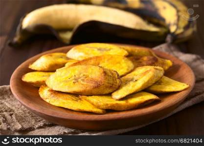 Fried slices of ripe plantains, a traditional and popular snack and accompaniment in Central America and Northern South America, photographed with natural light (Selective Focus, Focus on the front of the top slice)