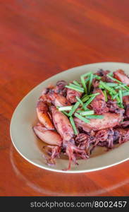 fried squid. plate of sauteed small squid fried with garlic and sauce