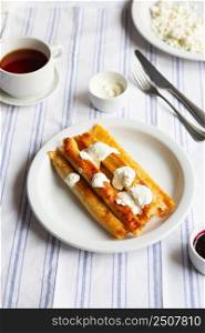 Fried Stuffed Pancakes Blintzes. Russian thin pancakes with cottage cheese, sour cream and jam. Healthy traditional breakfast.Tasty stuffed pancakes crepes with fillings. Children&rsquo;s menu.