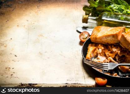 Fried trout at the plate with a fork. On an old rustic background .. Fried trout at the plate with a fork.