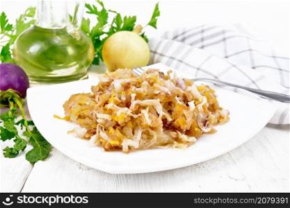 Fried turnips with onions in a plate, oil in a decanter, napkin on the background of light wooden board