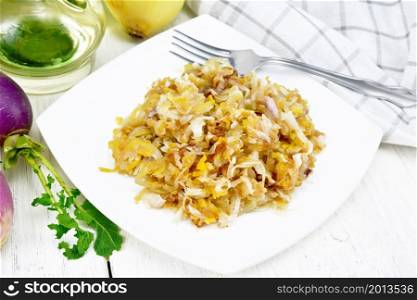 Fried turnips with onions in a plate, oil in decanter, a towel on wooden board background