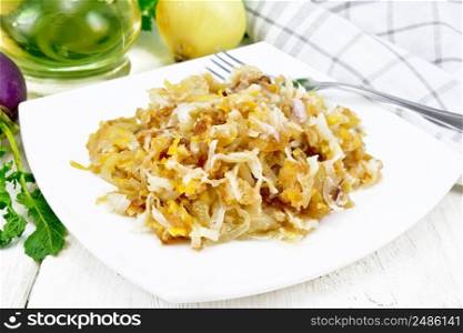 Fried turnips with onions in a plate, oil in decanter, a towel on white wooden board background