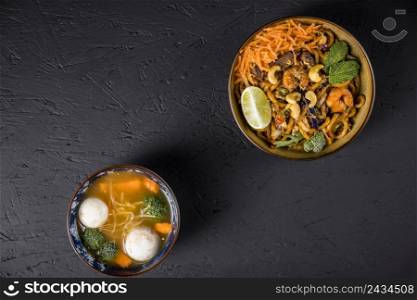 fried udon noodles with fish ball vegetable soup black concrete textured background