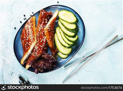 Fried unagi eel with sauce sesame and rice close-up
