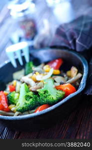 fried vegetables in pan and on a table