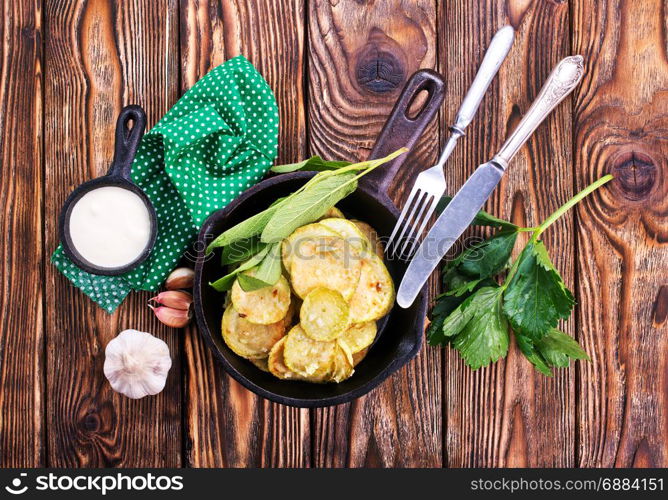 fried zucchini in metal pan and on a table