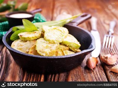 fried zucchini in metal pan and on a table
