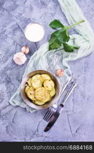 fried zucchini in metal pan and on a table