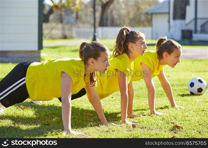 Friend girls teens push up push-ups workout ABS in a park turf grass